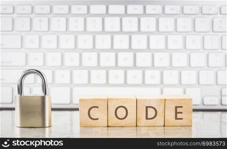 Close keypad lock with word CODE on wooden cubes, white keyboard on background. Encryption, internet access, cyber security, cryptography, system login, information processing, data privacy concepts.