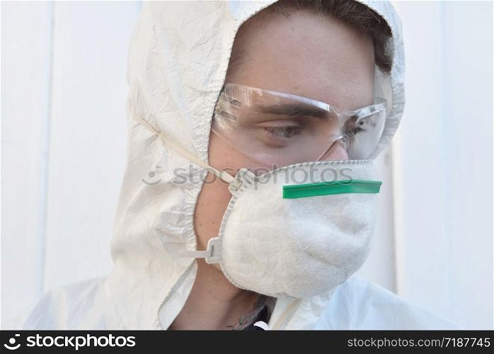 close on a man wearing protection glasses and dust mask on white background . close on a young man wearing protection glasses and dust mask on white background