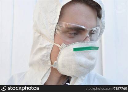close on a man wearing protection glasses and dust mask on white background . close on a young man wearing protection glasses and dust mask on white background