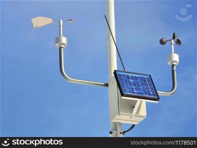 close on an anemometer with solar panel on blue sky