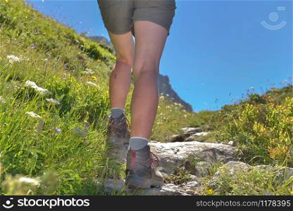 close on legs of a woman hiking on a path in mountain