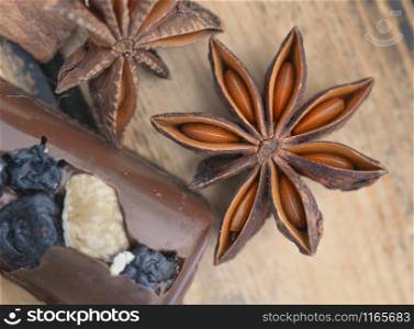 close on star anise with chocolat on brown wooden background