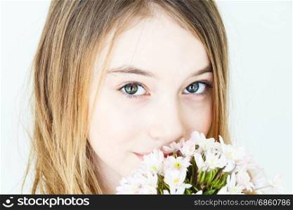 Close portrait of girl eleven years old with big green eyes with white flowers