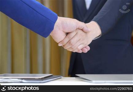 Close up 2 business people shaking hands after meeting finished in office room, concept of success, dealing and partnership