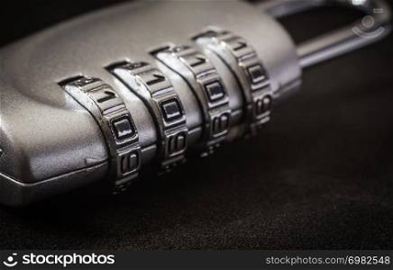 Close up 4 digits code number on silver combination pad lock on black background, dim light dark tone. data protection, key management, password access, security encryption concepts.