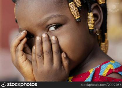 close up african girl covering her face