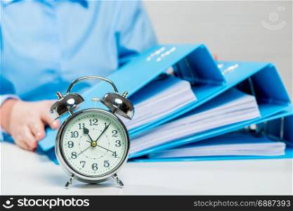 Close-up alarm clock and business documents out of focus