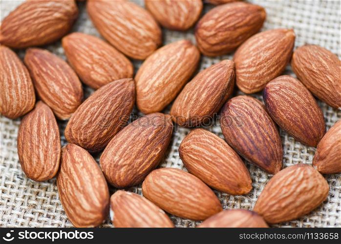 Close up almond nuts natural protein food and for snack / Almonds on sack background