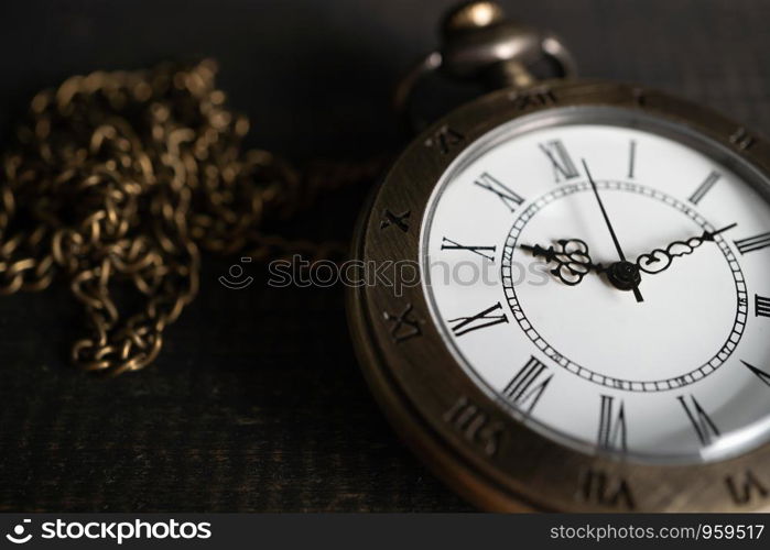 Close Up Antique pocket watch Placed on a black wooden background. copy space for text