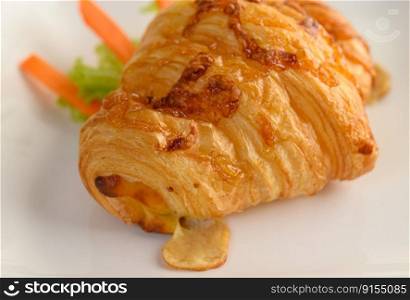Close up Appetizers the Croissant with hotdog on white plate beautifully with carrot and lettuce, delicious dessert for coffee break, copy space