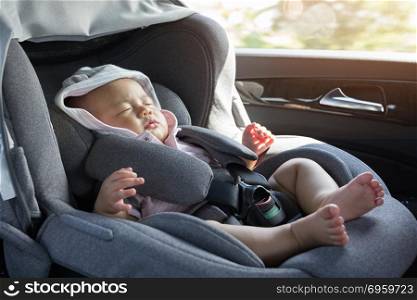 Close Up Asian cute newborn baby sleeping in modern car seat.. Close Up Asian cute newborn baby sleeping in modern car seat. Child new born traveling safety on the road. Safe way to travel fastened seat belts in a vehicle with young kids. Trip with an infant.