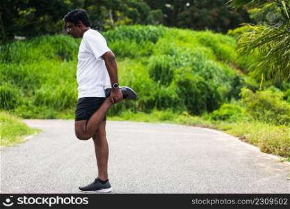 Close up Asian young athlete sport runner black man wear watch lift feet stretching legs and knee before running at the outdoor street health park, healthy exercise before workout concept