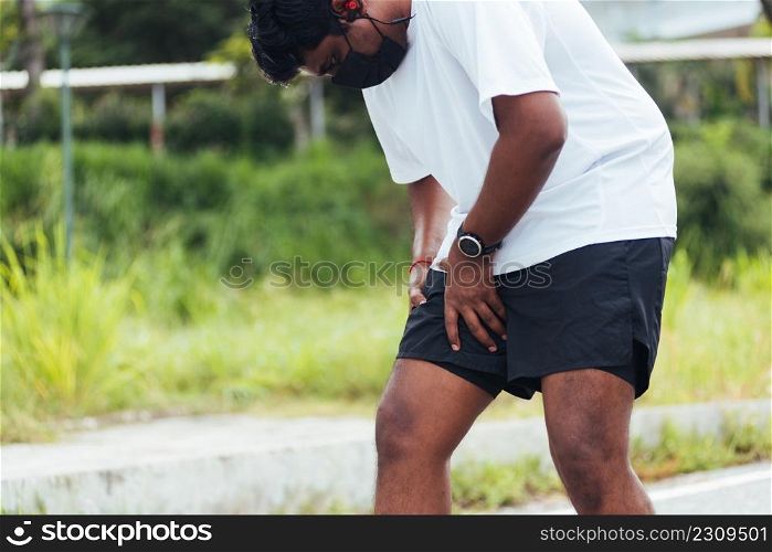 Close up Asian young sport runner black man wear watch hands joint hold leg she has thigh pain while running at the outdoor street health park, healthy exercise injury muscle from workout concept