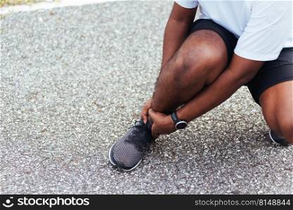 Close up Asian young sport runner black man wear watch hands joint hold leg pain because of twisted ankle broken while running at the outdoor street health park, healthy exercise Injury from workout