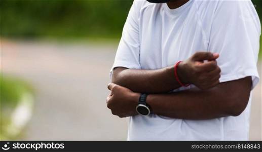 Close up Asian young sport runner black man wear watch he having elbow pain and use hands joint hold elbow while exercising at the outdoor street health park, healthy exercise Injury from workout