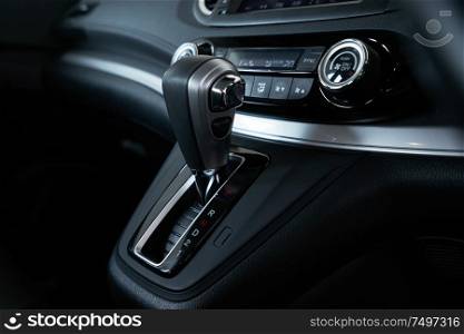 Close up automatic gear stick inside modern luxury car interior .