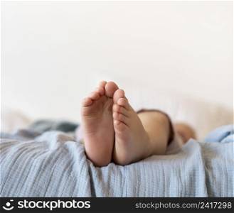 close up baby feet sitting bed
