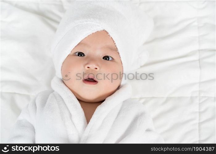 close up baby in soft bathrobe on a bed