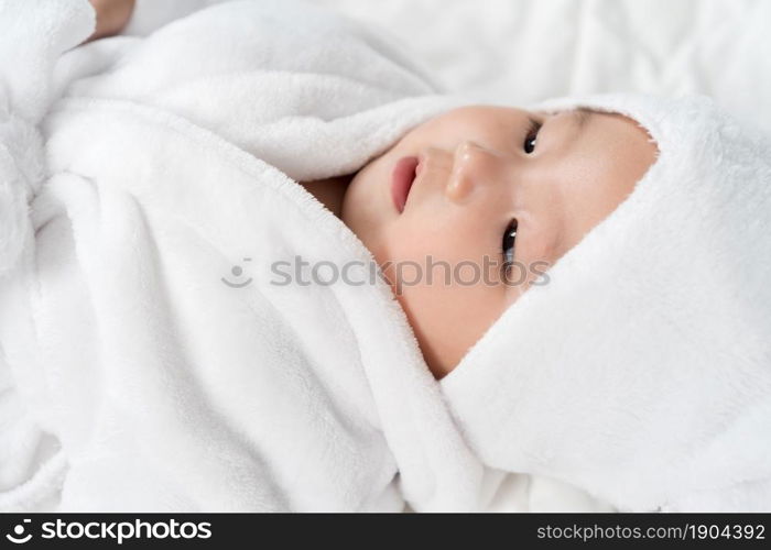 close up baby in soft bathrobe on a bed