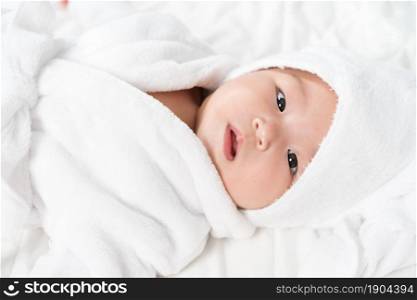 close up baby in soft bathrobe on a bed