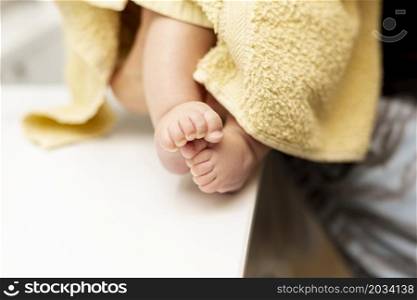 close up baby legs with yellow towel