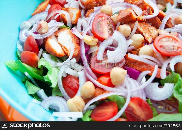 Close up barbeque chicken salad with chick peas, onion and vegetables