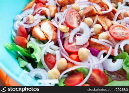 Close up barbeque chicken salad with chick peas, onion and vegetables