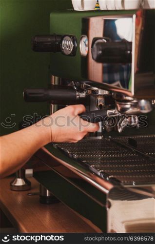 Close-up barista grinding coffee for flavored espresso. Process of preparation espresso