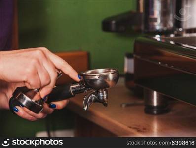 Close-up barista grinding coffee for flavored espresso. Process of preparation espresso