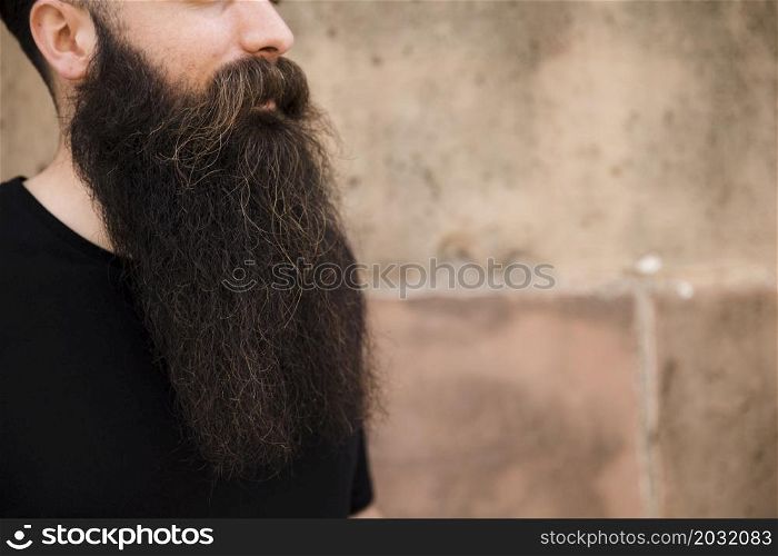close up bearded young man against wall