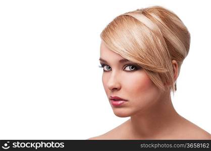 close up beauty portrait of a young and cute blond girl with hair style over white. Her face is turned three quarters, she looks in to the lens with actractive eyes.
