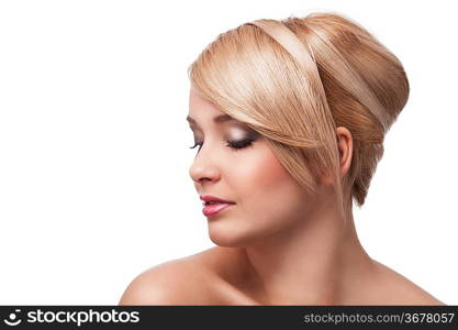 close up beauty portrait of a young and cute blond girl with hair style over white. she&acute;s almost turned in profile, looks down and slightly smiles.