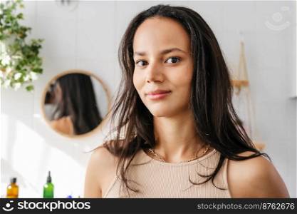 Close up beauty portrait of hispanic woman in bathroom. Confident young woman feeling positive and comfortable in her body. Woman’s power. Wellness. Close up portrait of beautiful mixed-race woman