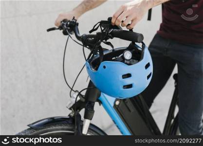 close up bicyclist putting helmet bycicle handle