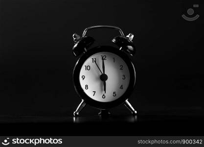 close-up. Black old style alarm clock isolated on black background.. Black old style alarm clock isolated on black background. close-up
