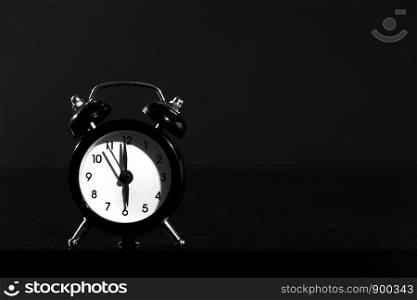 close-up. Black old style alarm clock isolated on black background.. Black old style alarm clock isolated on black background. close-up