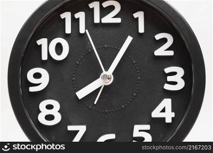 close up black wall clock face white background