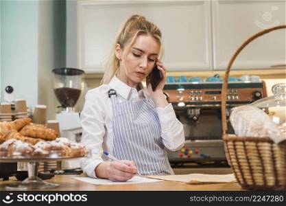close up blonde young bakery shop owner taking phone order