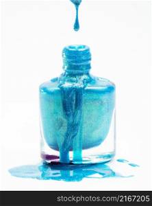 close up blue glitter nail polish dropping its flask against white background