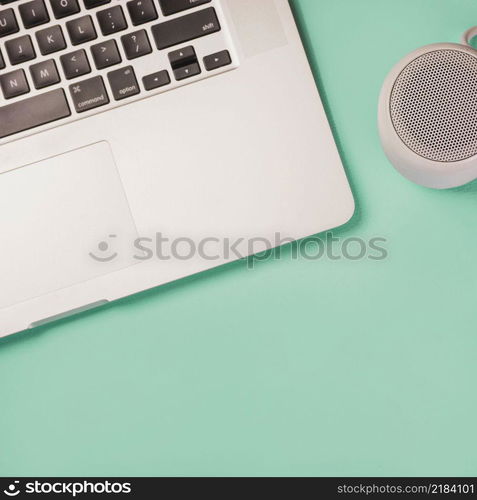 close up bluetooth speaker laptop green background