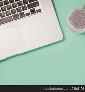 close up bluetooth speaker laptop green background