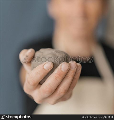 close up blurry man holding clay