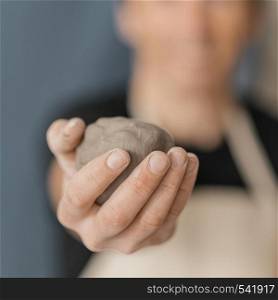 close up blurry man holding clay