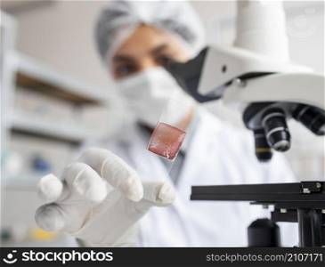 close up blurry scientist holding glass slide