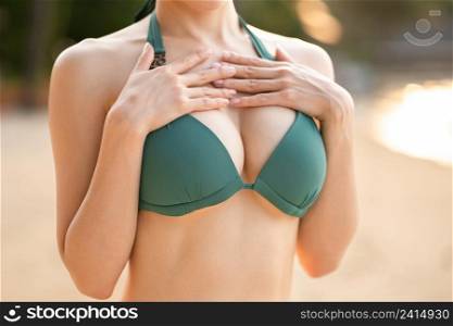 Close up boobs, sexy woman body wearing bikini on the beach.