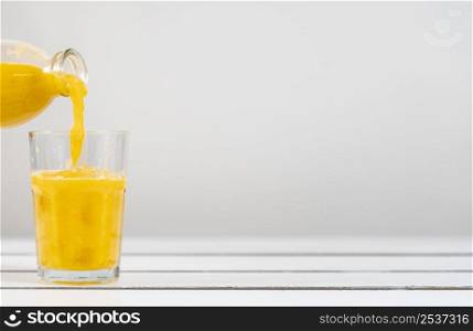 close up bottle pouring juice glass