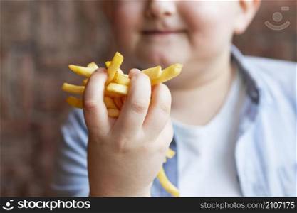 close up boy holding french fries