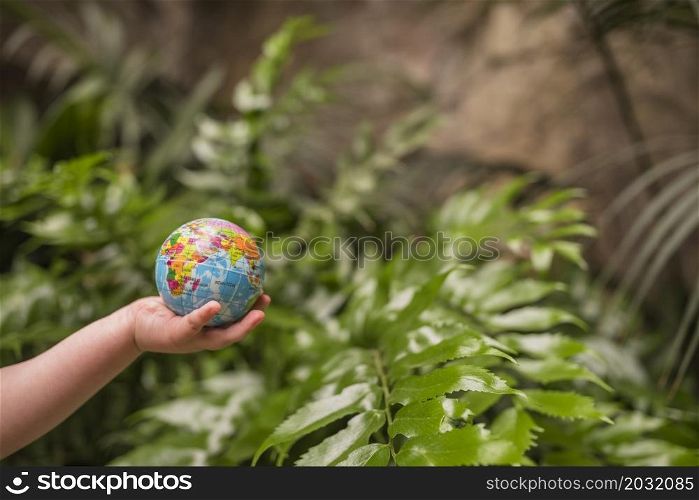 close up boy s hand holding inflatable globe ball
