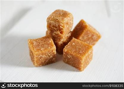 Close up brown cane sugar on white background, selective focus . Close up brown cane sugar on white background