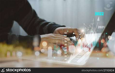 Close up Businessman working on table office deck for business growth up or stock market 2022 with data statistics level up of graph or chart.Financial and Technology concept ,planning and strategy.